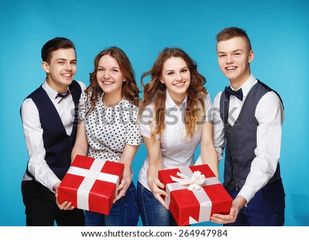 Business people holding red gift boxes. Female and male model studio posing. Hipster Style