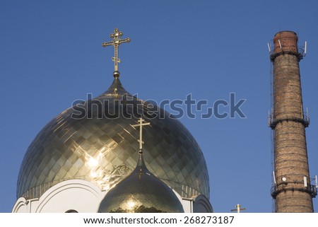 Photo of Christian Orthodox church against the sky and the chimney.