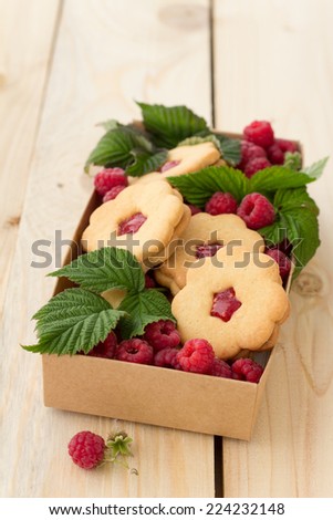 Homemade cookies with raspberry jam and fresh raspberries