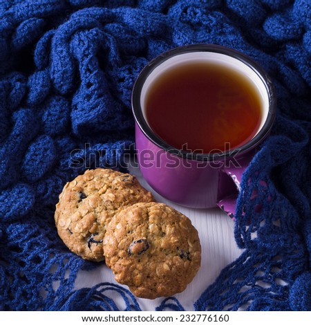 Cup of hot tea, oatmeal cookies and warm scarf