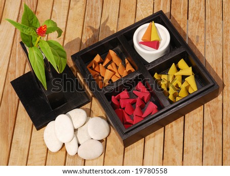 Set for aromatherapy. Colored aromatic incense with ceramic plate in black wood box.