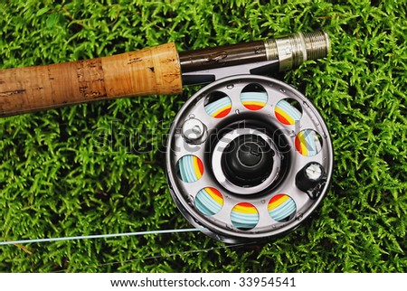 Fishing tackle (fly rod and reel) on wet moss