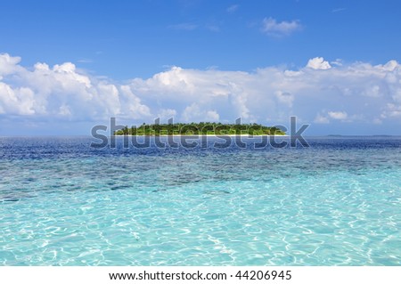 Tropical paradise - clear water, sky and deserted island.