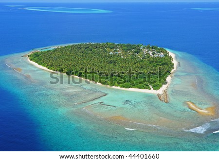 Paradisaic Maldivian island with turquoise beaches, green trees and deep blue sky.