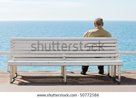 Old men sitting on the bench by the sea.