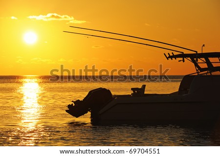 Fishing speed boat with fishing rods at sunset in the ocean