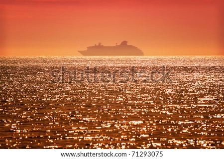 Beautiful sunset with a cruise ship setting out on its journey on horizon