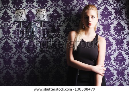 Fashion studio shot of beautiful woman with makeup and hairstyle wearing evening dress