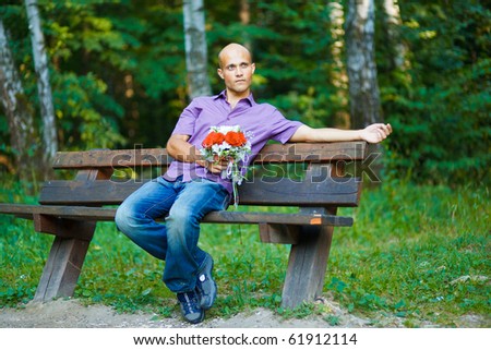 Photo of handsome guy with bouquet waiting for his girlfriend outside