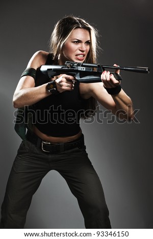 Sexy woman with rifle on dark