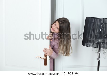 Little girl standing at the white door closed