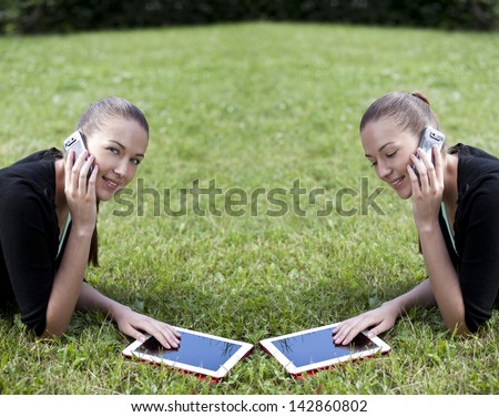 Young woman lying on the grass with phone in hand