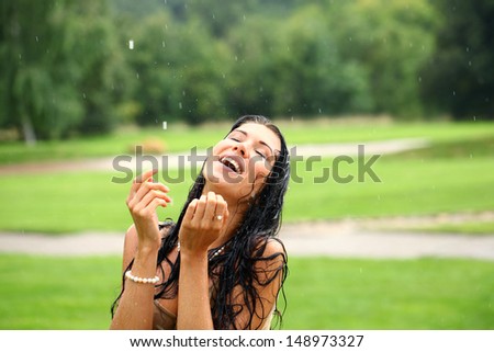 Young happy woman walking in the rain