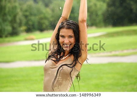 Young happy woman walking in the rain