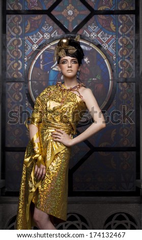 Glamor lady in gold gown in the church