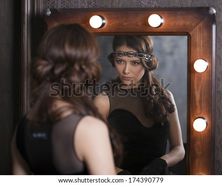 Mirror reflection of a young caucasian woman applying makeup