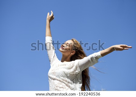Portrait of young woman enjoying life against the blue sky