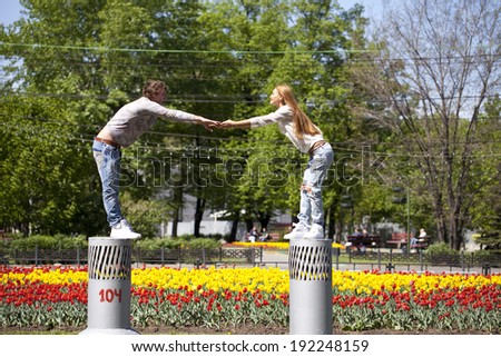 Loving couple drawn to each other against summer park