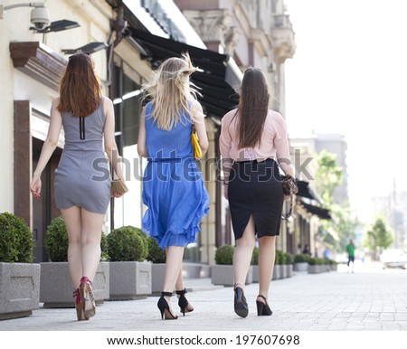 Three sexy women in dress back away on the street in Moscow city
