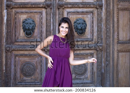 Young beautiful woman in bright dress near the wooden wall