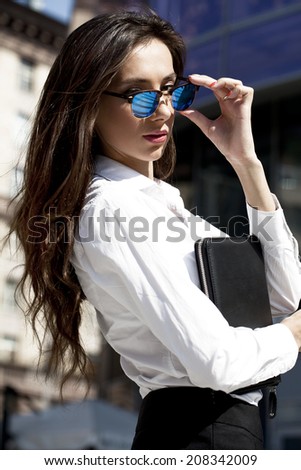 Young beautiful business woman with blue mirrored sunglasses