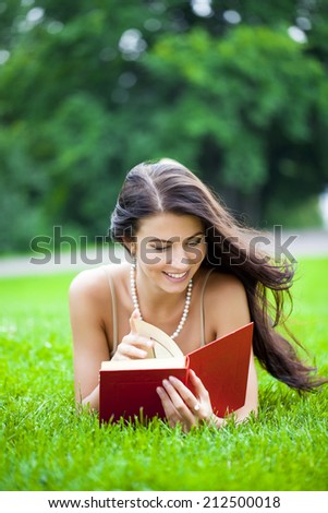 Young beautiful woman reading a book outdoor
