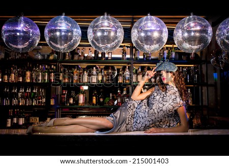 Sexy young woman lying on the bar at a nightclub