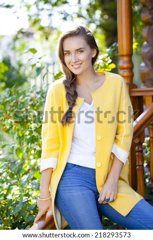 Beautiful young woman standing on the porch of a wooden house