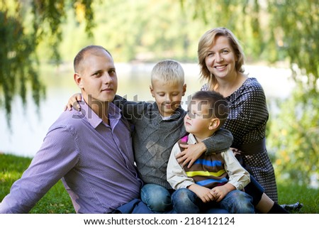 Russian family, young parents and two sons in autumn park