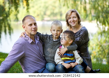 Russian family, young parents and two sons in autumn park