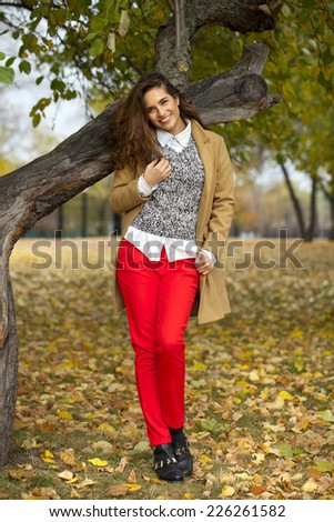 Beautiful Young woman in fashion coat walking in autumn park