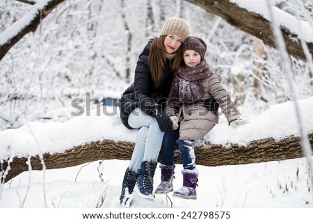 Portrait of a nine year girl with her mother in winter park