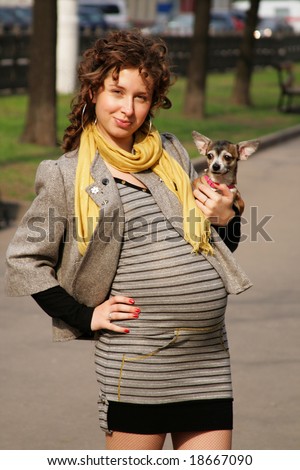 The pregnant woman walks the dog