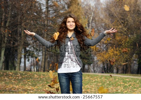 Girl among flying leaves