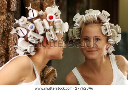 Hair curlers. A portrait of the young girl with hair curlers on a head