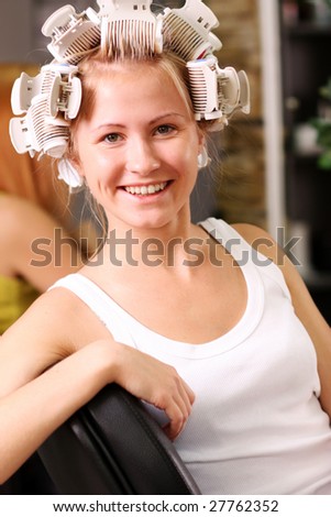Hair curlers. A portrait of the young girl with hair curlers on a head