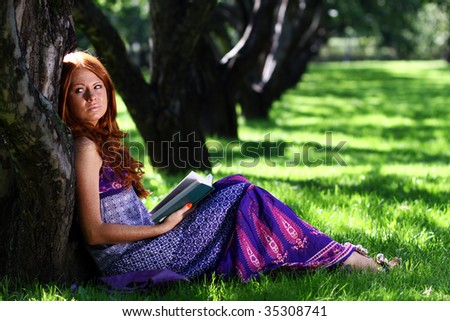 beautiful girl reads the book in park