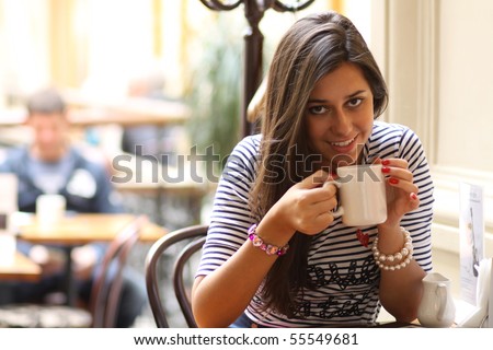 Beautiful young girl sipping coffee