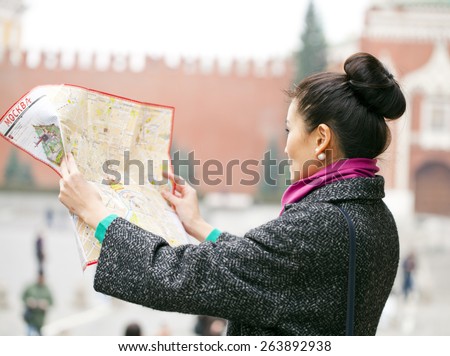Young beautiful asian girl holding a tourist map of Moscow, Russia. The inscription on the tourist map: \