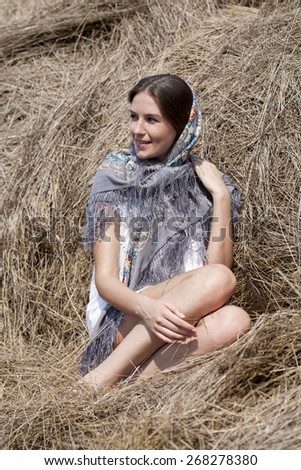 Portrait of a beautiful young woman in a blue scarf on the background of the loft