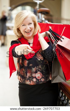 Mature happy blonde woman with shopping bags