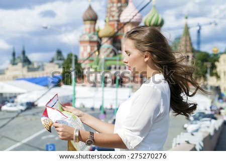 Young beautiful blonde girl holding a tourist map of Moscow, Russia