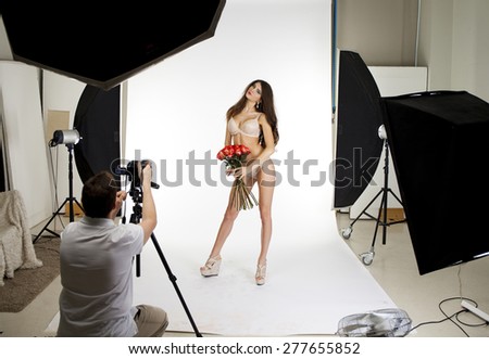 Working conditions in the studio, the photographer photographs the professional model