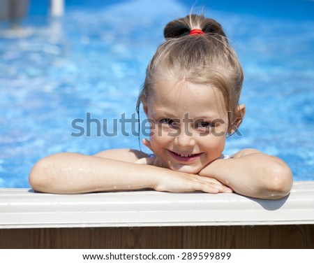 Happy little Girl in blue bikini swimming pool