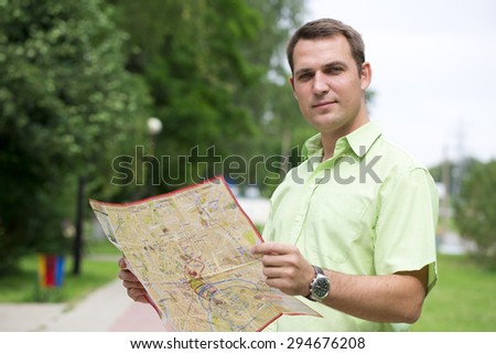 Young male tourist with map in hand good looking. Tourist map of the city of Moscow, Russia (no trademark)