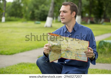 Young male tourist with map in hand looking around. Tourist map of the city of Moscow, Russia