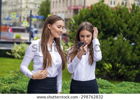 Two Young beautiful business women in white shirt on summer street