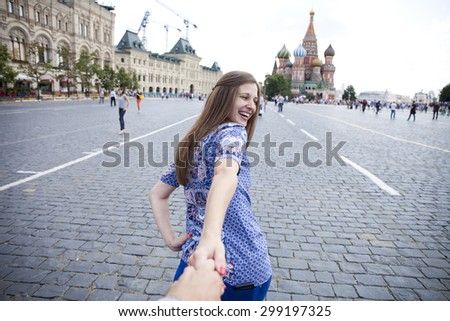 Follow me. Young happy girl pulls the guys hand on the Red Square in Moscow, Russia