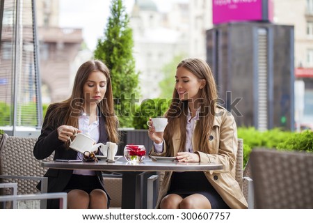 Two young business women having lunch break together in a coffee shop