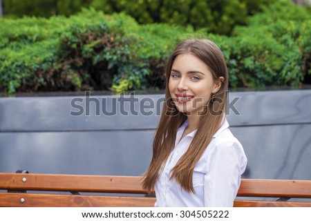 Young beautiful business woman in white shirt on summer street